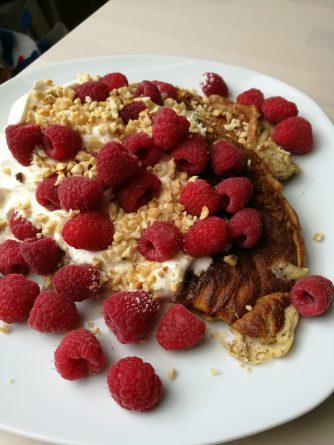 Fluffige Keto Pancakes mit Mascarpone auf einem Teller, serviert mit frischen Beeren und Sahne – perfekte Low-Carb Frühstücksidee.