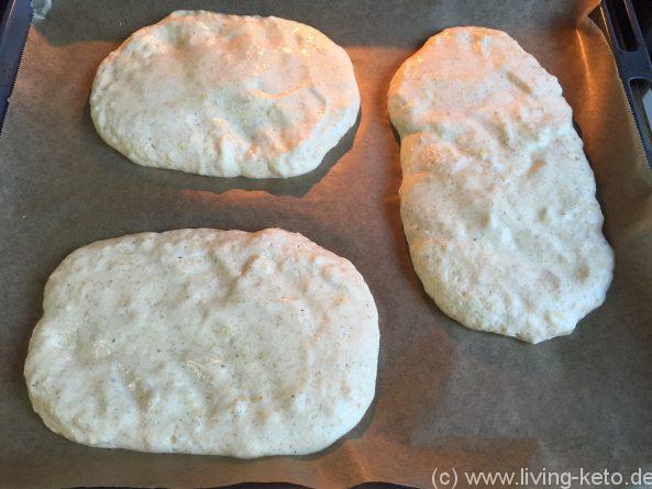 Ketogener Pizzabrot-Teig vor dem Backen – luftige Mischung aus Frischkäse, Eiern und Käse auf einem mit Backpapier ausgelegten Blech.