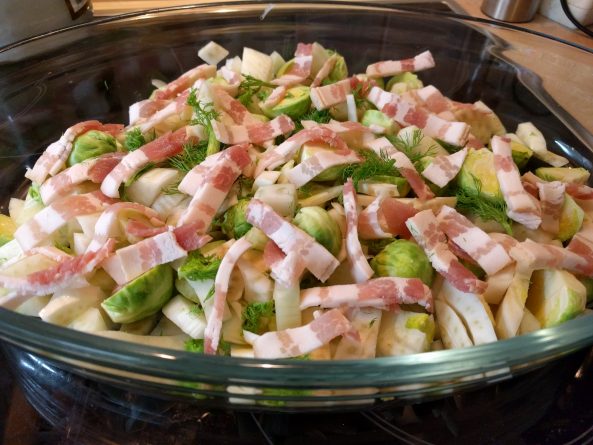 Frischer Rosenkohl, Fenchel und Bacon-Streifen in einer Auflaufform, bereit für die ketogene Zubereitung.  