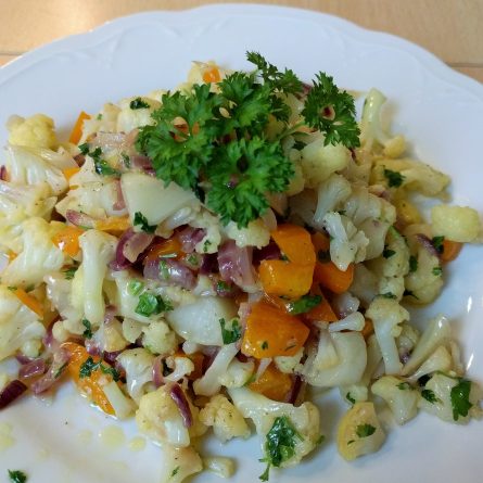 Italienische Blumenkohlpfanne auf einem weißen Teller, garniert mit frischer Petersilie – ketogen, fruktosearm und lecker.