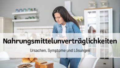 Frau mit Bauchschmerzen steht in einer Küche; Titeltext „Nahrungsmittelunverträglichkeiten – Ursachen, Symptome und Lösungen“ überlagert das Bild.