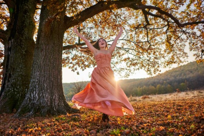 Frau tanzt frei und glücklich in der Natur, Symbol für innere Leichtigkeit und Selbstverantwortung bei Lipödem.