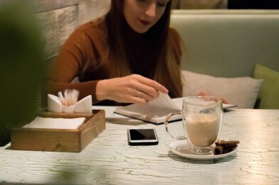 Frau beim Planen eines Wochenplans - Mealprep für ketogene Ernährung mit einem Heißgetränk